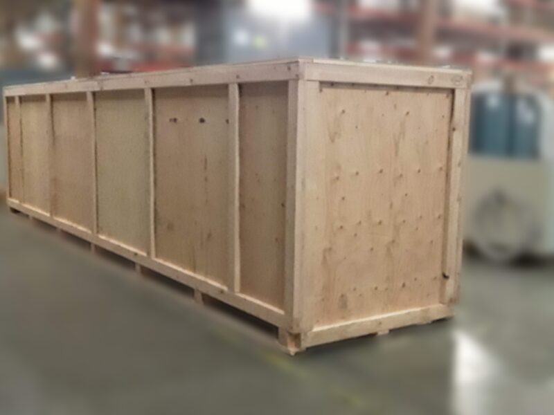 A long custom wooden shipping crate on its pallet base on the shop floor.